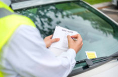 Parking officer writing parking charge notice time limit